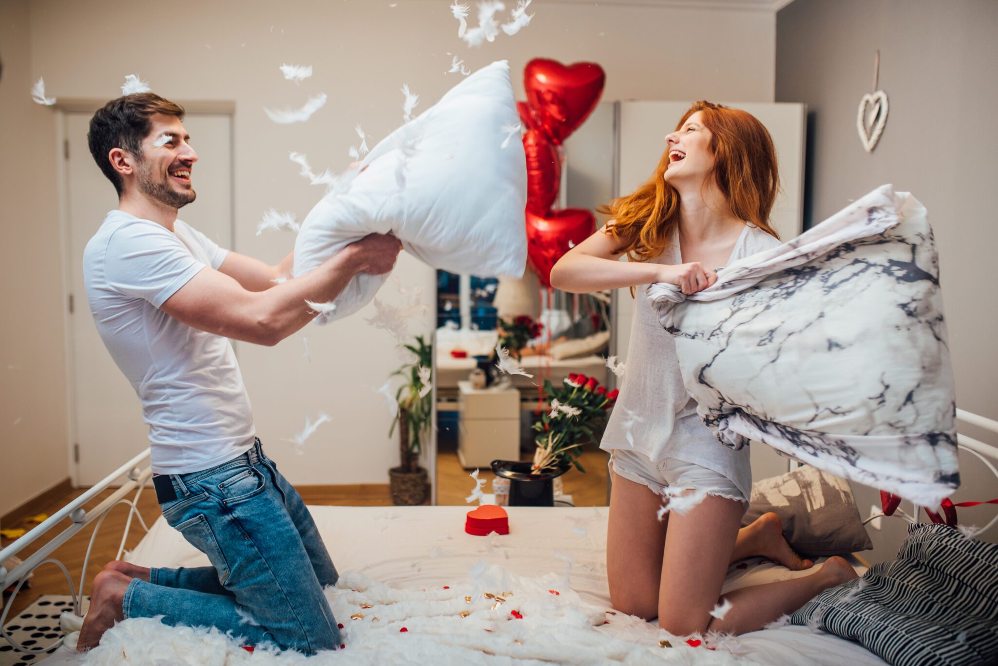 Laughing couple with feathers flying