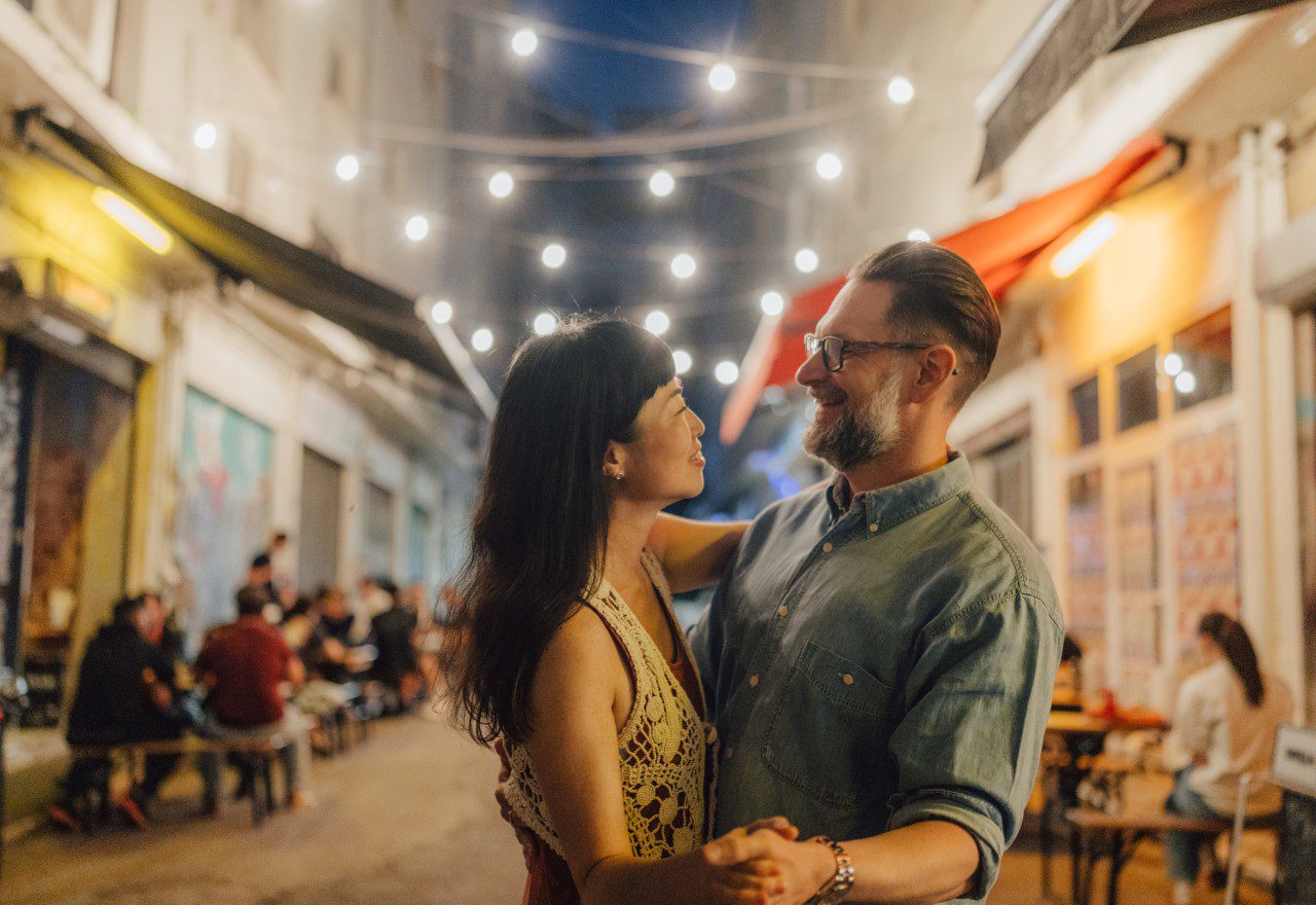 Couple dancing under string lights