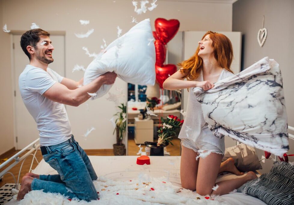 Laughing couple with feathers flying